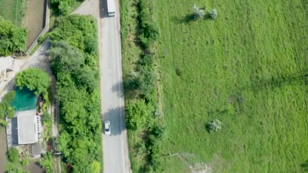 Vue aérienne du haut vers le bas suivant un bus sur une route dans une zone rurale 