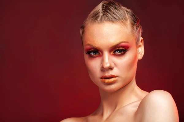 High Fashion model woman with stylish makeup on red background
