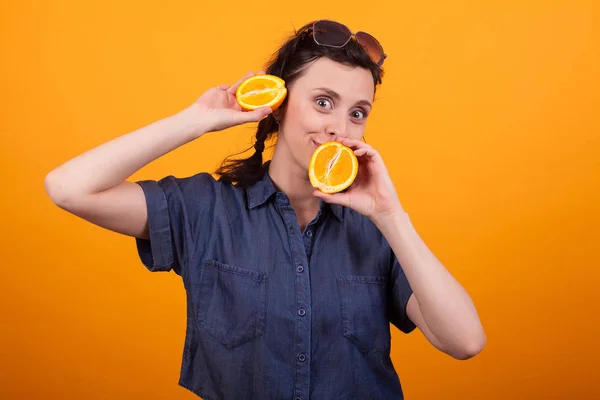 Jolie jeune femme tenant des fruits d'été en studio sur fond jaune — Photo