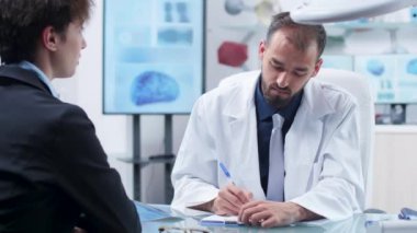 Modern ofis veya araştırma merkezinde hekim genç bir kadından notlar alıyor