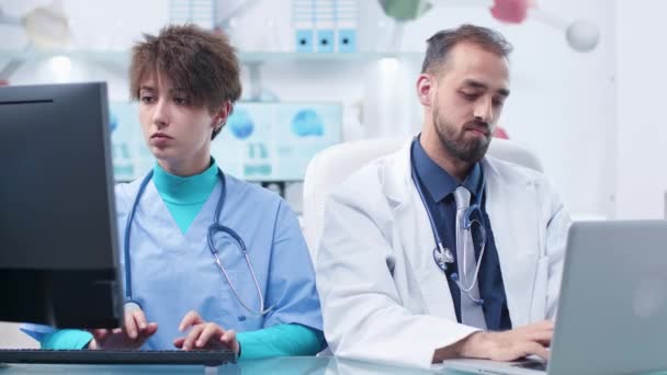 Médico explicando algo a una enfermera estudiante — Vídeo de stock