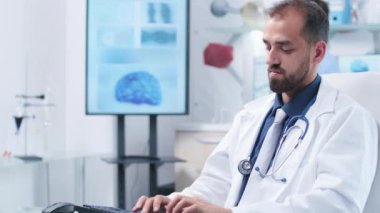 Modern araştırma merkezinde bir doktor bilgisayar klavyesi üzerine yazıyor