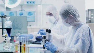 Modern ve profesyonel laboratuvarda kimyacılar renkli sıvılarla tüpler bakıyor