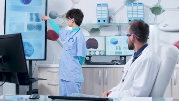 Junge Krankenschwester im modernen Büro im Gespräch mit dem Arzt — Stockvideo