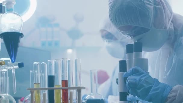 Close up handheld shot van chemici werken in een laboratorium gevuld met dampen of rook — Stockvideo