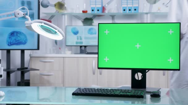 Υπολογιστής με πράσινη οθόνη μακέτα στο γραφείο γιατρού — Αρχείο Βίντεο