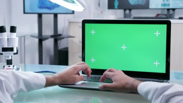 緑色の画面でラップトップで作業する男性開業医の手のPov映像をクローズアップ — ストック動画