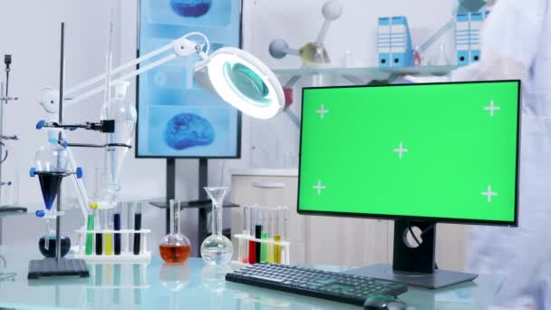 Доллі знімок надійного науково-дослідного центру з зеленим екраном монітора на столі спереду — стокове відео