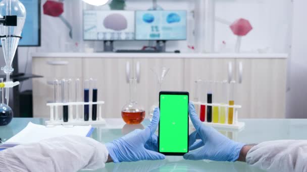 Фотография ученого, держащего смартфон с зеленым экраном — стоковое видео