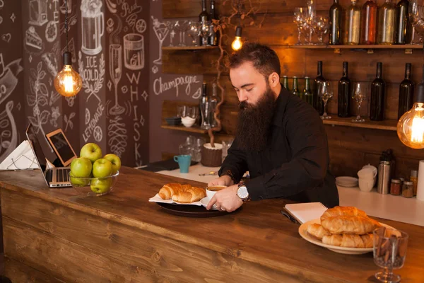 Barman guapo detrás de una barra con un café preparado . — Foto de Stock