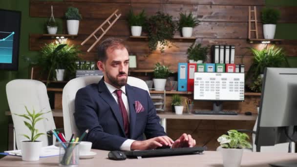 Zoom en la toma de hombre de negocios que trabaja solo en la oficina con diseño moderno — Vídeos de Stock