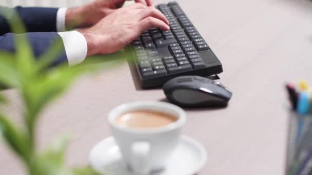 Zakenman bij zijn bureau met behulp van een computer toetsenbord — Stockvideo