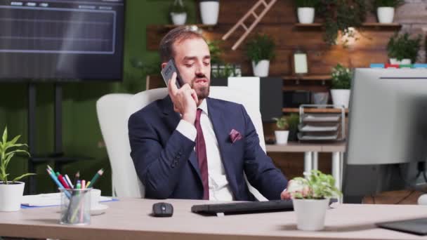 У сучасному офісі, після робочих годин, бізнесмен говорить по телефону — стокове відео