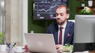 Modern, yaratıcı görünümlü iş ofisinde genç işadamı bir görüntülü görüşme yapıyor