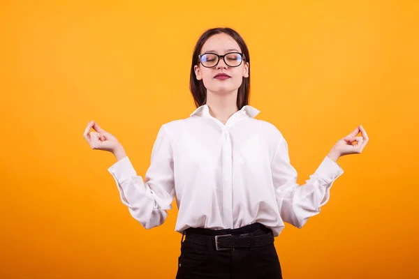 Porträtt Pretty Teenage Girl meditera i studion över gul bakgrund — Stockfoto