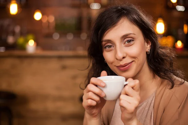 매력적인 백인 여자 밀링 과 보고 카메라 와 a 커피 컵 손 — 스톡 사진