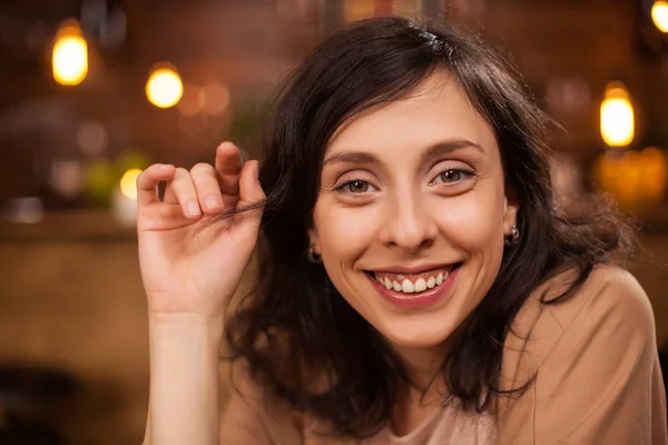 Крупный план портрета красивой женщины в кофейне, улыбающейся в камеру — стоковое фото