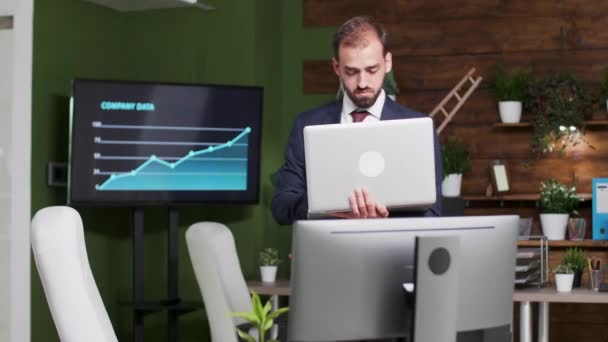 Geschäftsmann allein im Büro mit Laptop in der Hand — Stockvideo