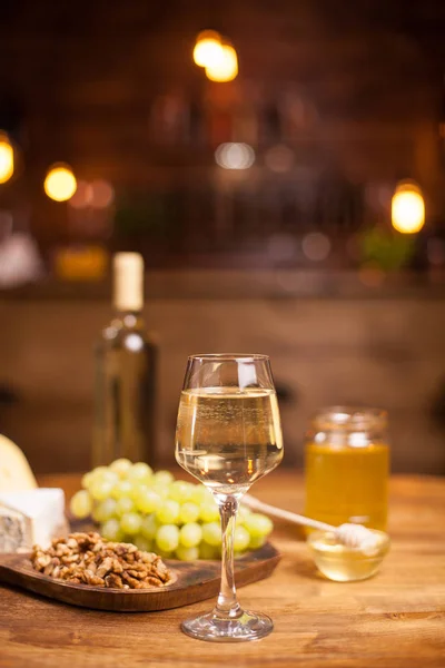 Rafined csendélet a bor, szőlő, különböző sajtok több mint rusztikus fából készült asztal egy Vintage pub — Stock Fotó