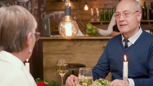 Senior man looking curious at his wife during their date — Stock Photo, Image