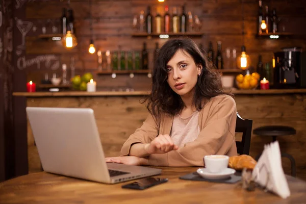 Atractiva mujer caucásica usando su portátil en una cafetería con conexión interent — Foto de Stock