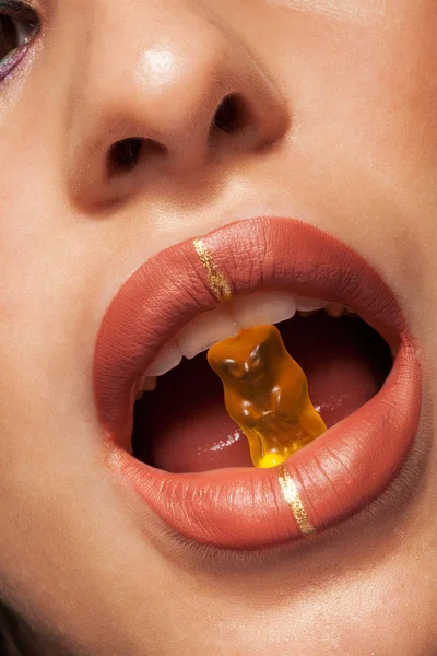 Zbliżenie piękna kobieta usta z gummy Bear — Zdjęcie stockowe