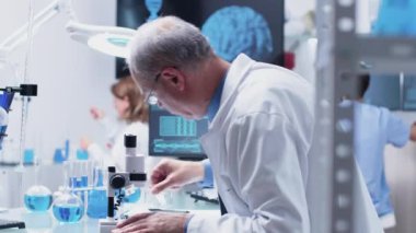 Dolly bir mikroskop kullanarak olgun kimyager yakın çekim