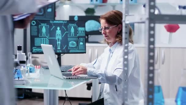 Em laboratório moderno cientista mulher tipos no laptop — Vídeo de Stock