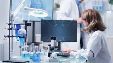 Modern araştırma laboratuvarında iki bilim adamı tartışıyor.