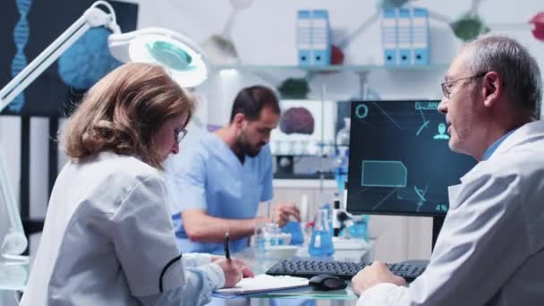 Equipo de científicos trabajando en un laboratorio ocupado — Vídeos de Stock