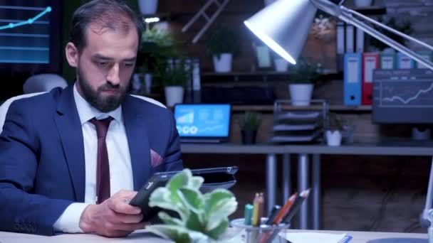 Менеджер поздно ночью в офисе использует цифровой планшетный компьютер — стоковое видео