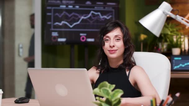 Jeune femme d'affaires assise sur le bureau, regardant la caméra — Video