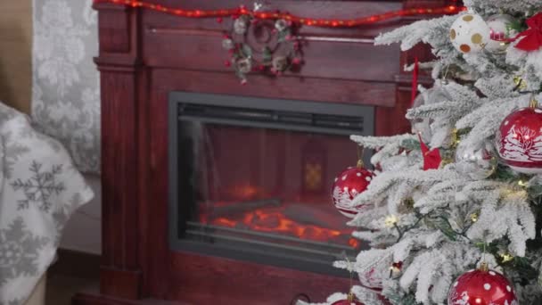Schön geschmückter Weihnachtsbaum und daneben ein Kamin — Stockvideo