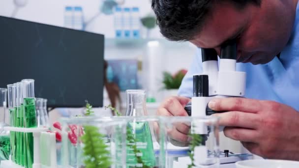 Revelando foto de assistente químico olhando para o microscópio — Vídeo de Stock