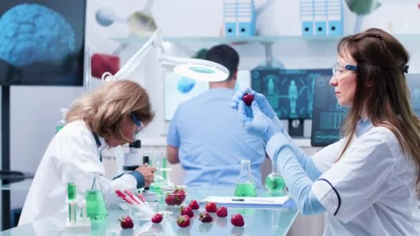 Em biologia cientista centro de pesquisa estão olhando para frutas — Vídeo de Stock