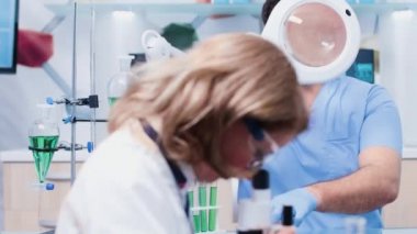 Erkek araştırmacı büyüteç altında çilek örnekleri bakarak