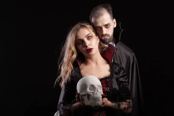 Romantic and imortal vampire couple looking into the camera for halloween carnival