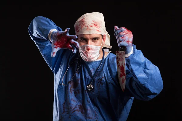 Доктор весь в крови с маской на лице на Хэллоуин в студии — стоковое фото