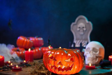 Cadılar Bayramı balkabağı ahşap bir masa üzerinde ürpertici bir kafatası önünde parlayan