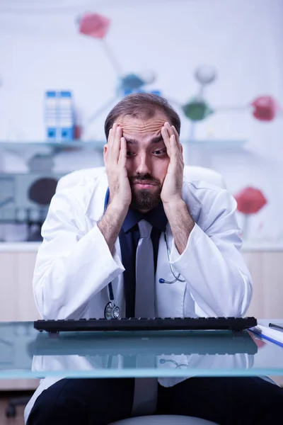 Retrato del joven médico burnout en su gabinete del hospital —  Fotos de Stock