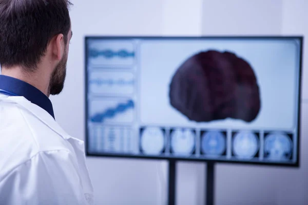 年轻的男外科医生使用技术检查病人的大脑 — 图库照片