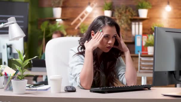 Стрессовая женщина с головной болью во время работы в офисе — стоковое видео
