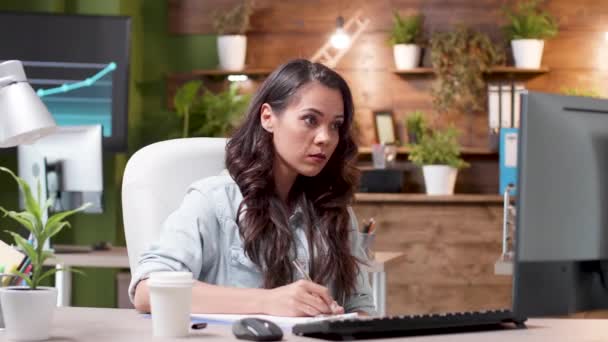 Mulher concentrada lê um e-mail e toma notas na área de transferência — Vídeo de Stock