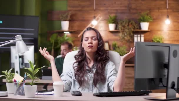 Mujer tratando de meditar mientras sus colegas en el fondo están muy estresados — Vídeo de stock