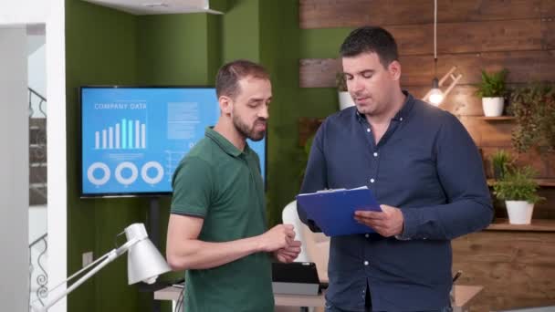 Twee mannelijke collega's met een gesprek in het kantoor — Stockvideo