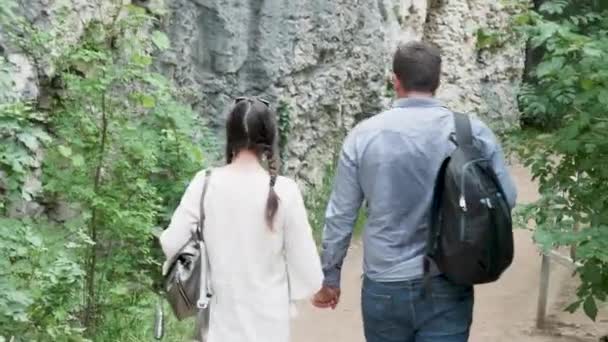 Pareja joven cogida de la mano y senderismo en las montañas — Vídeo de stock