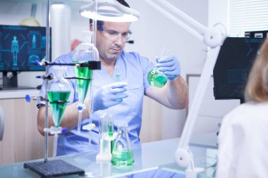 Bir araştırma laboratuarında iki test tüpü tutan genç bilim adamı