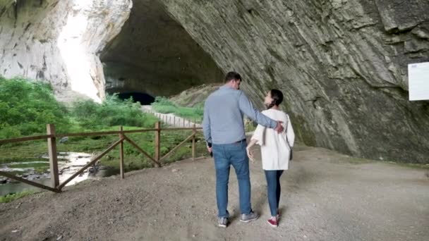 Pareja caminando en una gran cueva — Vídeos de Stock