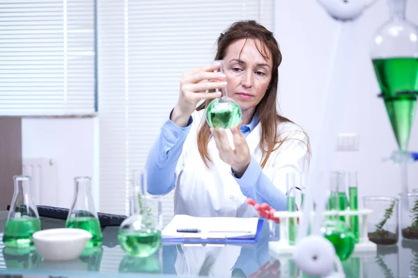 Científica buscando con gran atención una solución verde — Foto de Stock