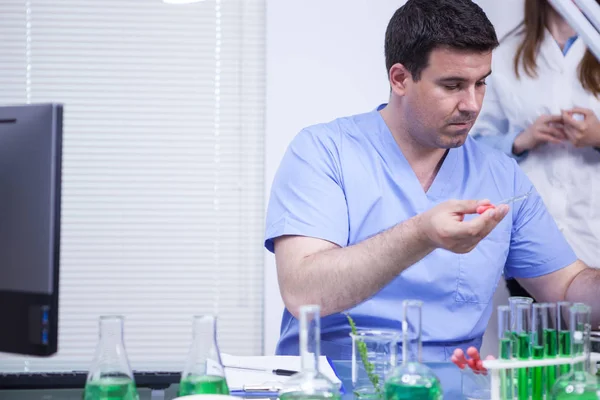 Hombre científico caucásico joven usando una pipeta para tomar una muestra de solución en una investigación de laboratorio de fábrica — Foto de Stock